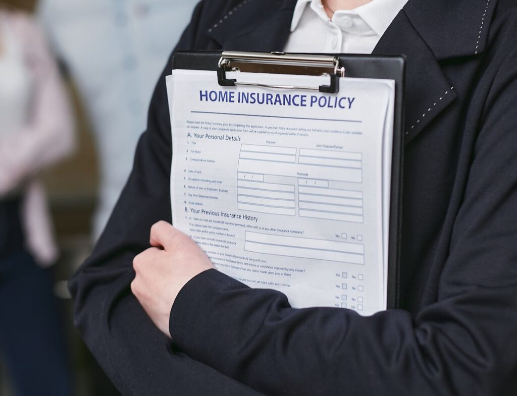 The Art of Drawing Readers In: Your attractive post title goes here Close-up of a person holding a home insurance policy on a clipboard, captured indoors.