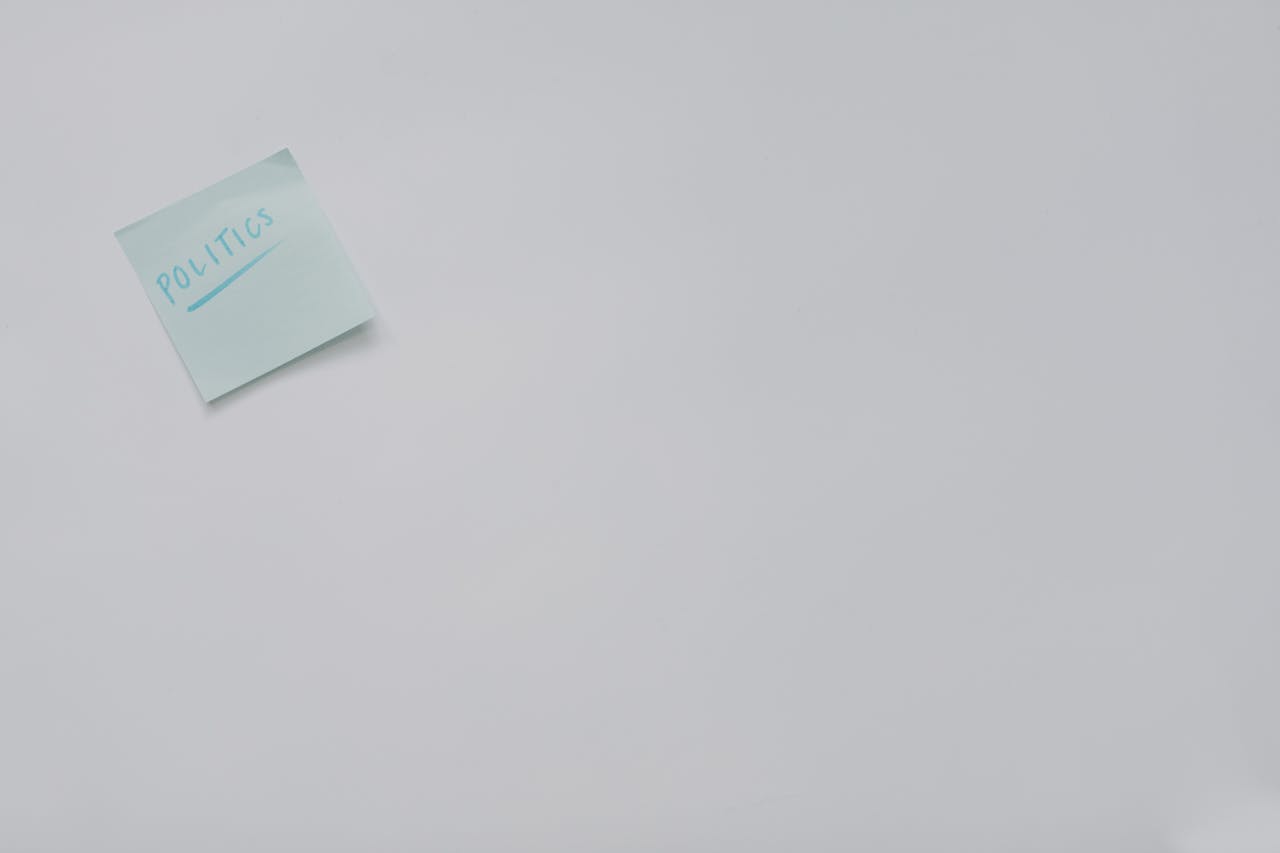 A simple sticky note with 'politics' written on it, offering ample copyspace.